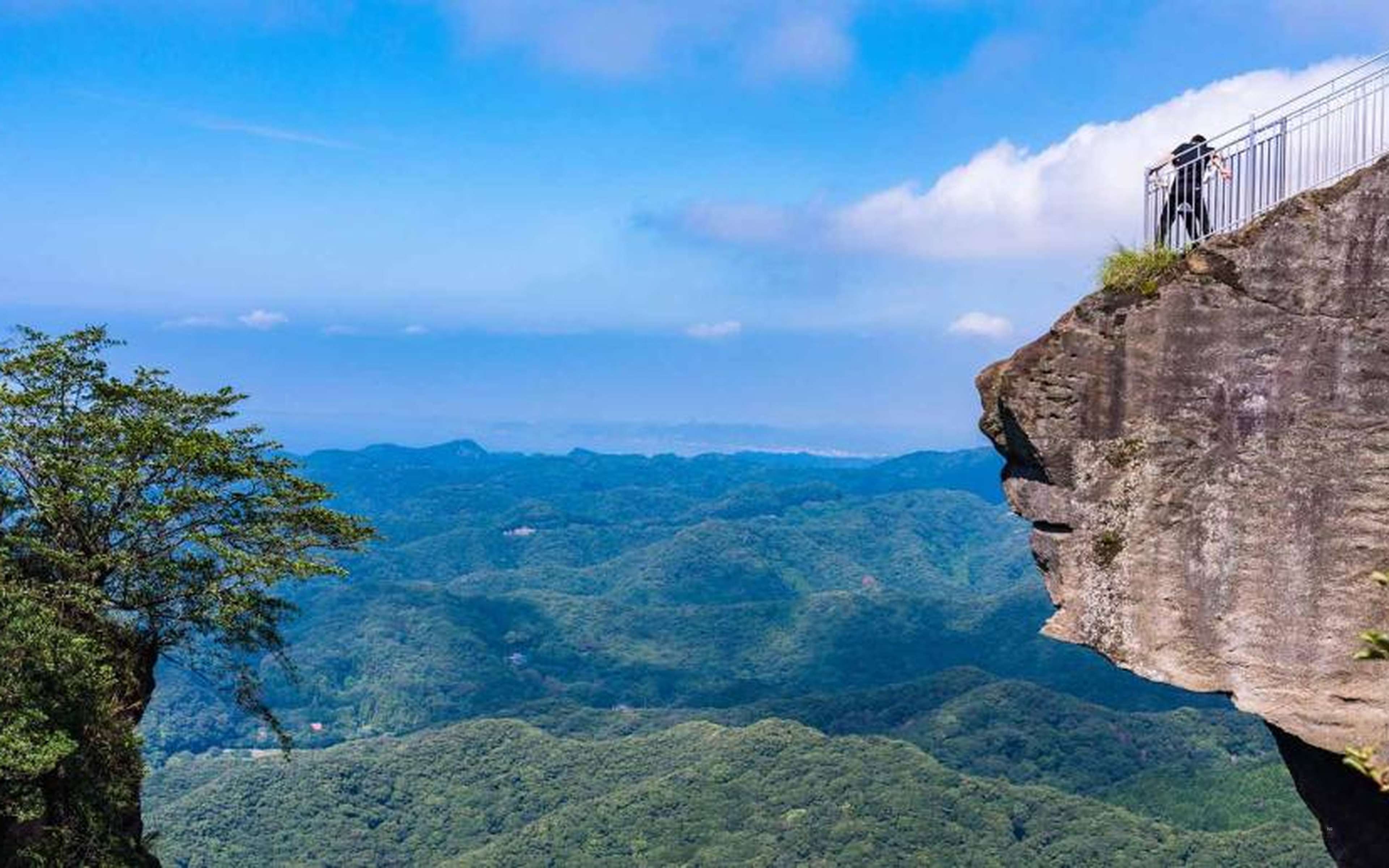 A viewing platform on top of a cliff, with forested hills beyond
