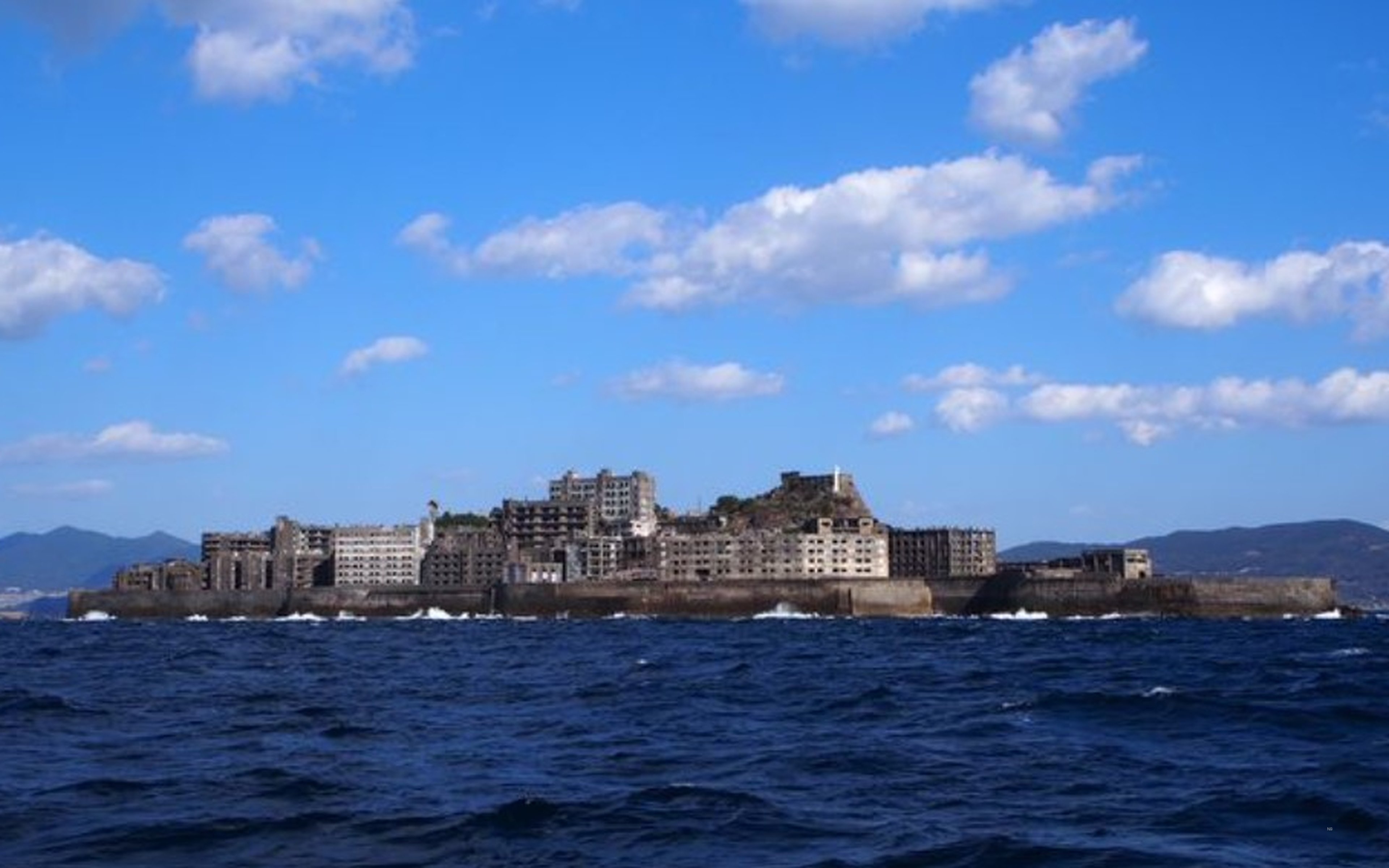 Gunkanjima (Hashima) island under a blue sky