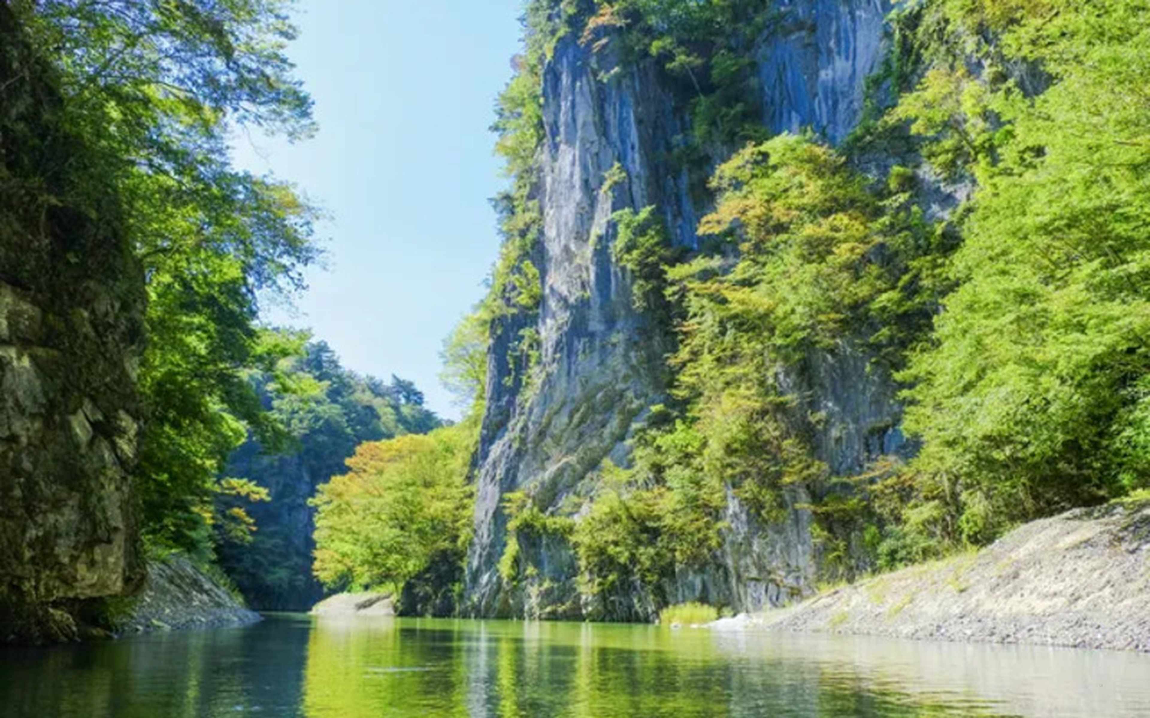 A green river flowing between sheer rock cliffs