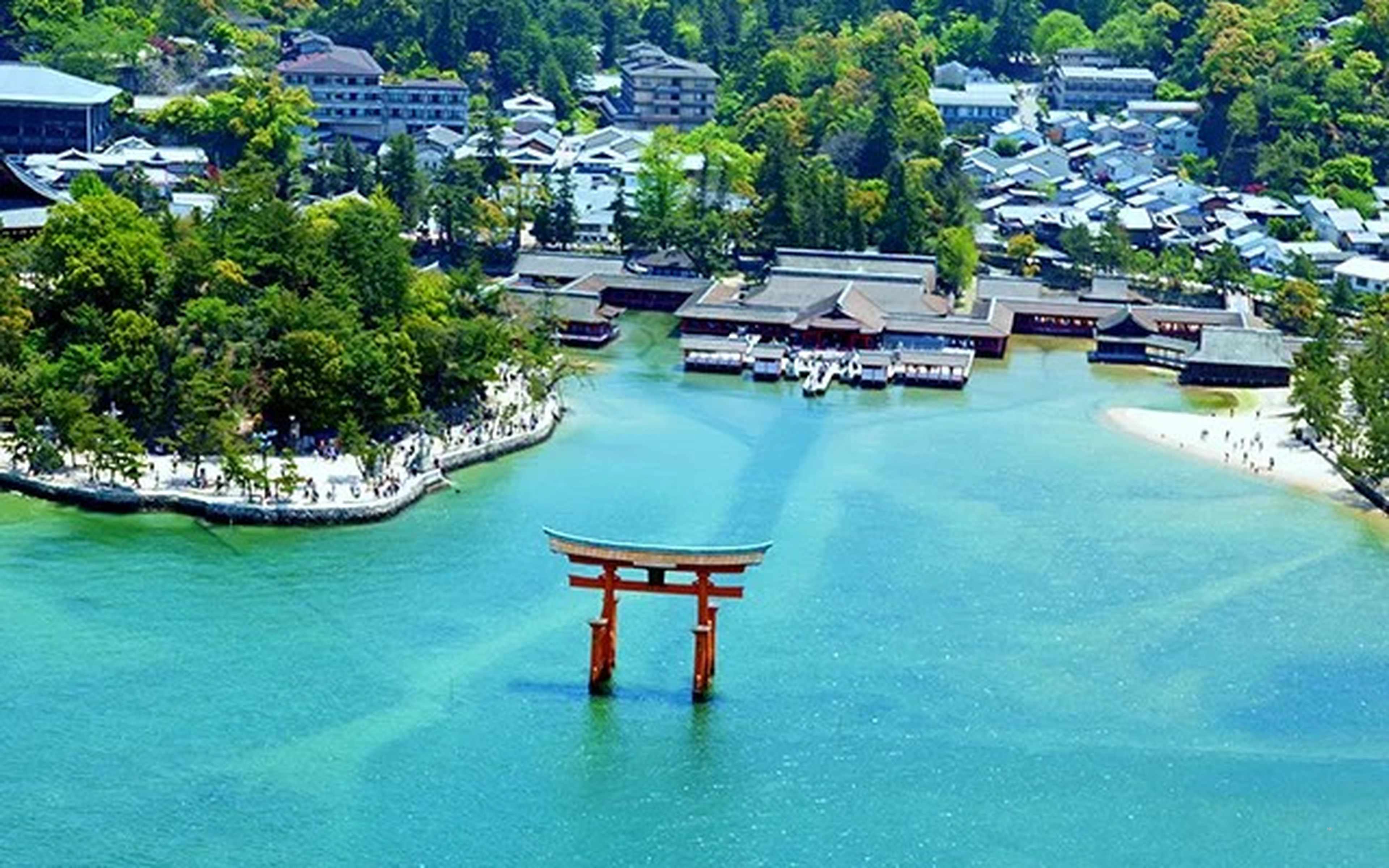 The vermilion torii gate standing in the sea at Miyajima, with the shrine halls behind it