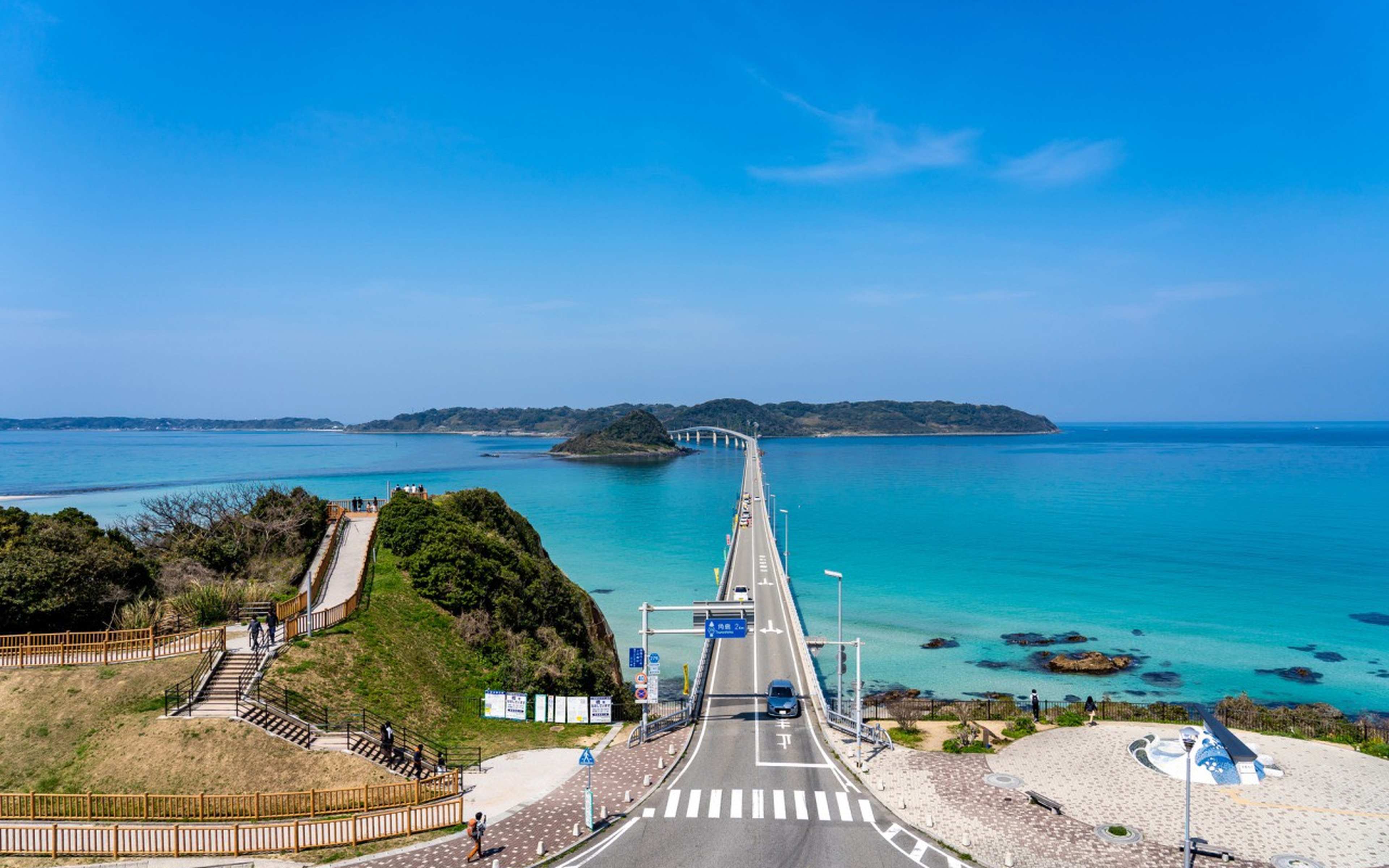 Tsunoshima Bridge running straight out across emerald water