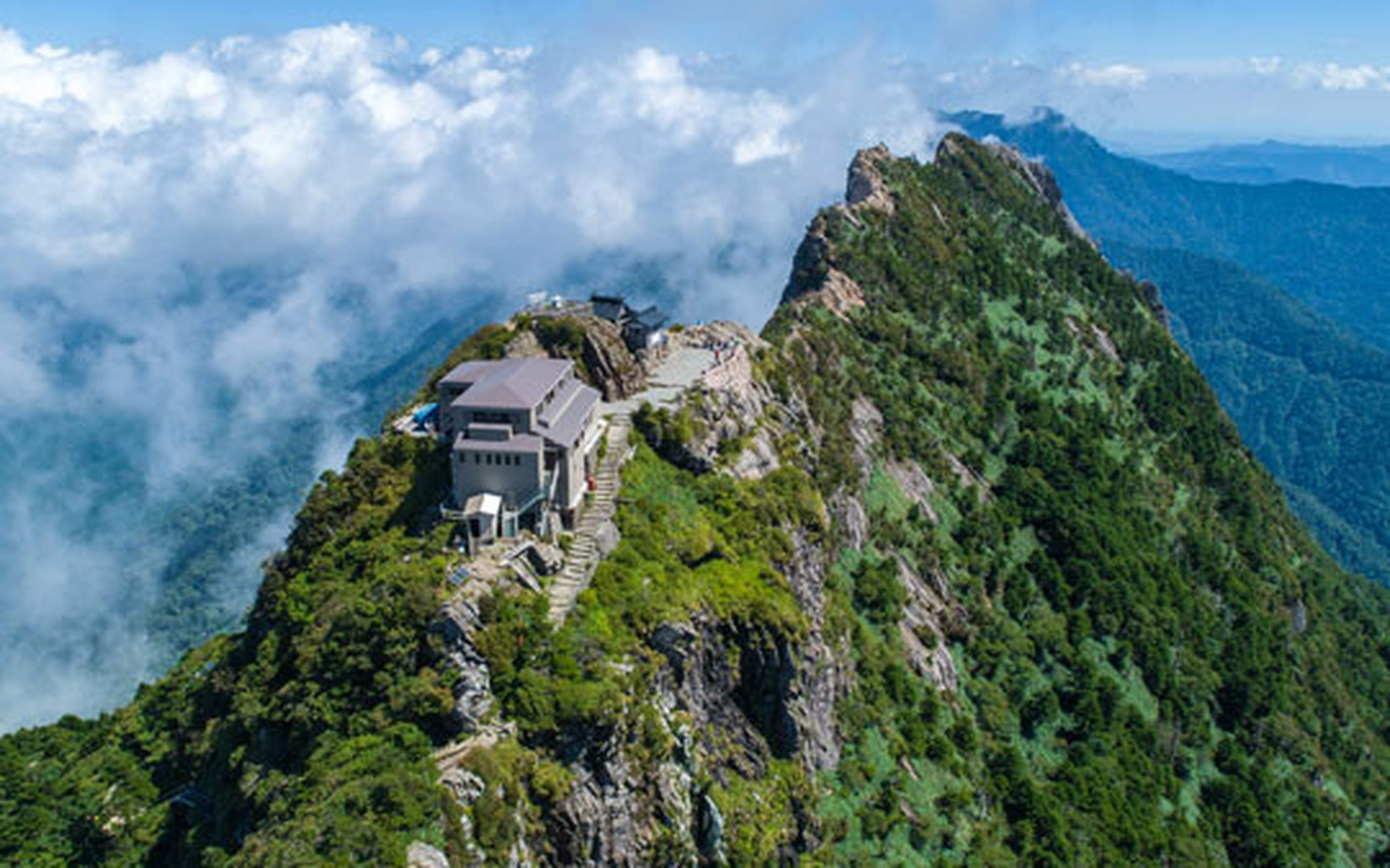 The summit and ridge of Mount Ishizuchi rising above the clouds
